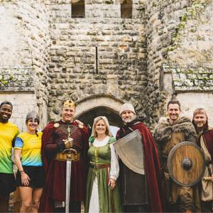 Des bénévoles et des coureurs devant un château fort
