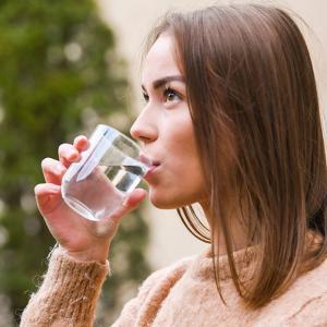 Une femme boit un verre d'eau