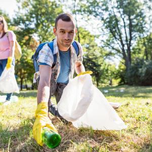 Un homme ramasse des déchets dans une forêt
