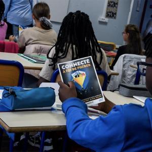 un collégien regarde un dépliant sur le harcèlement scolaire