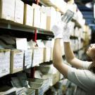 une femme observe une photographie dans un fonds d'archives