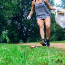 Une femme court et ramasse des déchets dans la nature
