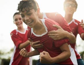 Des jeunes portant des maillots de foot en train de chahuter