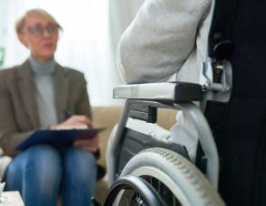 Une personne handicapée dans un fauteuil roulant devant une femme