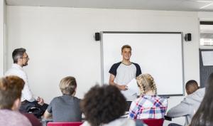 Un élève dans une classe de collège avec un professeur