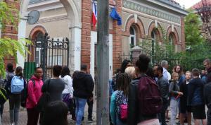 Des élèves sont groupés devant l'entrée du lycée Jacques Amyot