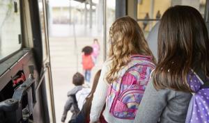 Des enfants descendent d'un bus scolaire