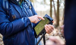 Un homme utilisant une tablette numérique dans la forêt