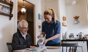 Une jeune femme aide une personne âgée