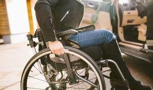 Une femme dans un fauteuil roulant près d'une voiture