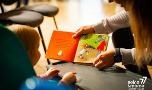 Un enfant lit un livre avec un parent