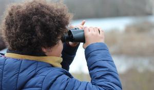 Un enfant observe la nature à travers des jumelles