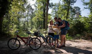 une famille avec des vélos dans une forêt