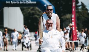 Porteur de la flamme paralympique en fauteuil roulant