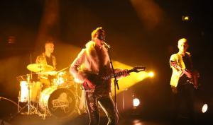 Un chanteur et des musiciens sur scène en concert
