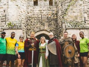 Des bénévoles et des coureurs devant un château fort
