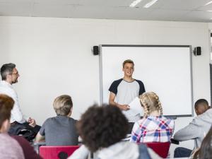 Un élève dans une classe de collège avec un professeur