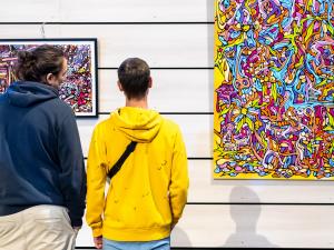 Deux personnes regardent une œuvre d'art contemporain exposée