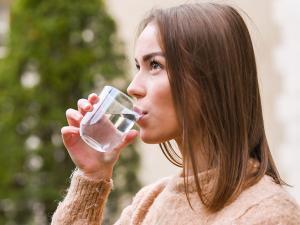 Une femme boit un verre d'eau