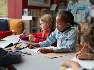 Un groupe d'enfants font du coloriage