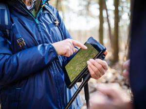 Un homme utilisant une tablette numérique dans la forêt