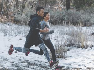 Une femme et un homme courent dans la neige