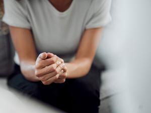 Une femme assise les mains croisées