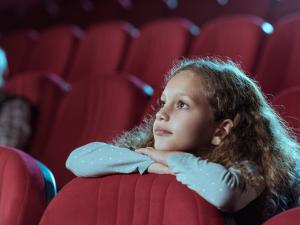 Une adolescente regarde un film au cinéma