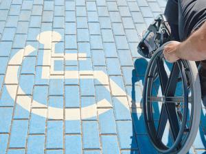 Une personne en fauteuil roulant sur une place réservée aux handicapés
