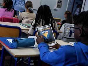 un collégien regarde un dépliant sur le harcèlement scolaire