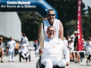 Porteur de la flamme paralympique en fauteuil roulant