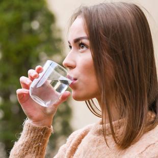 Une femme boit un verre d'eau