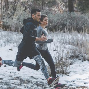 Une femme et un homme courent dans la neige
