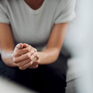 Une femme assise les mains croisées