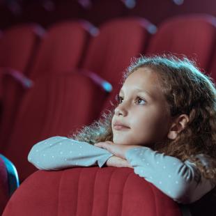 Une adolescente regarde un film au cinéma
