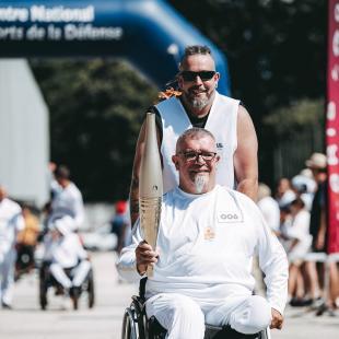 Porteur de la flamme paralympique en fauteuil roulant