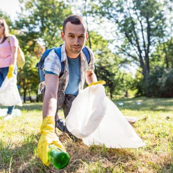Un homme ramasse des déchets dans une forêt