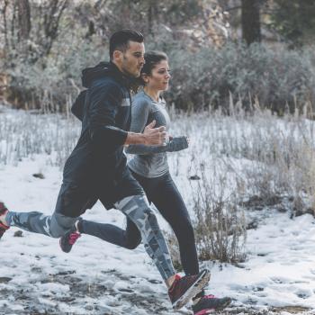 Une femme et un homme courent dans la neige