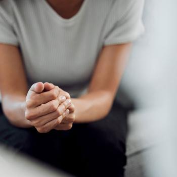 Une femme assise les mains croisées