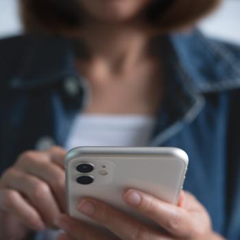 Une femme compose un numéro sur son smartphone