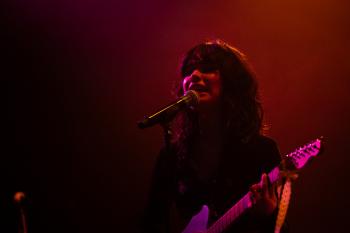 Chanteuse sur scène avec une guitare électrique