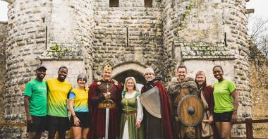 Des bénévoles et des coureurs devant un château fort