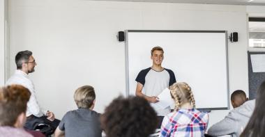 Un élève dans une classe de collège avec un professeur