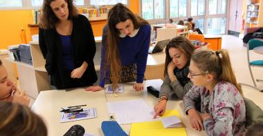 Des enseignants et des collégiens en groupe de travail en classe