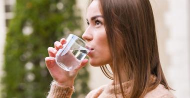 Une femme boit un verre d'eau