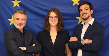 Equipe de travail devant le drapeau de l'Union européenne
