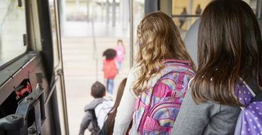 Des enfants descendent d'un bus scolaire