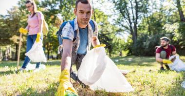 Un homme ramasse des déchets dans une forêt