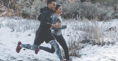 Une femme et un homme courent dans la neige