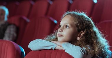 Une adolescente regarde un film au cinéma